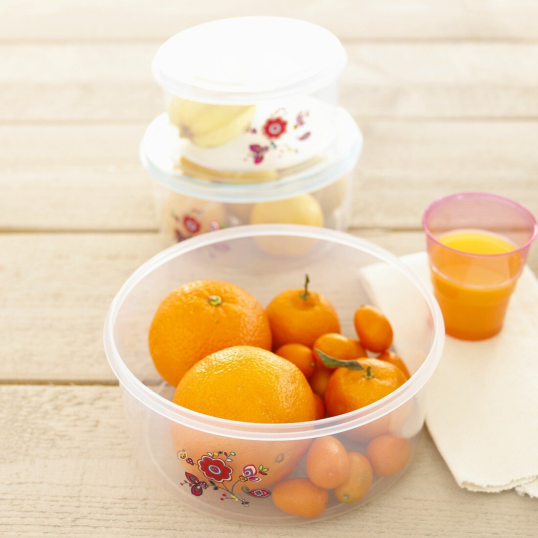 Fresh fruit in plastic containers, orange juice