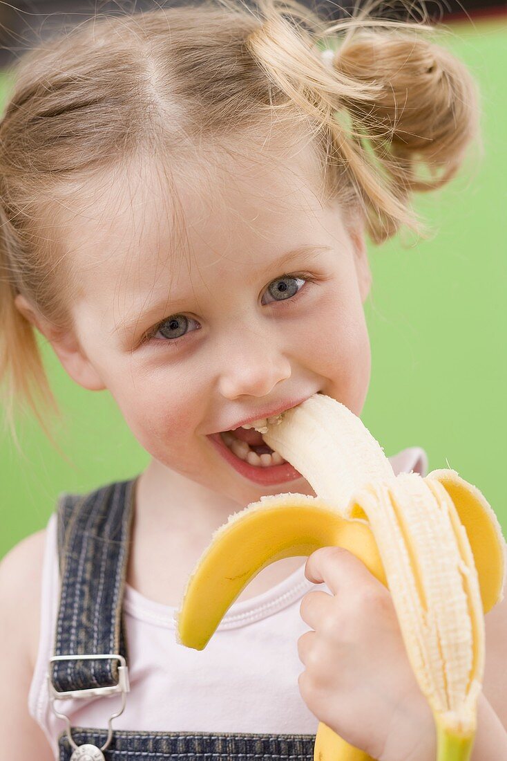 Little girl eating banana License Images 969917 StockFood