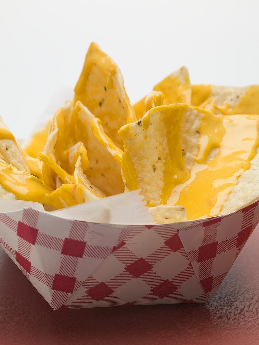 Nachos mit Käsesauce im Pappschälchen (Close Up)