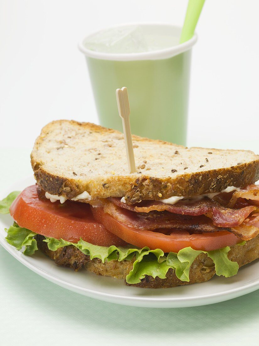 Bacon, lettuce and tomato sandwich, drink in background
