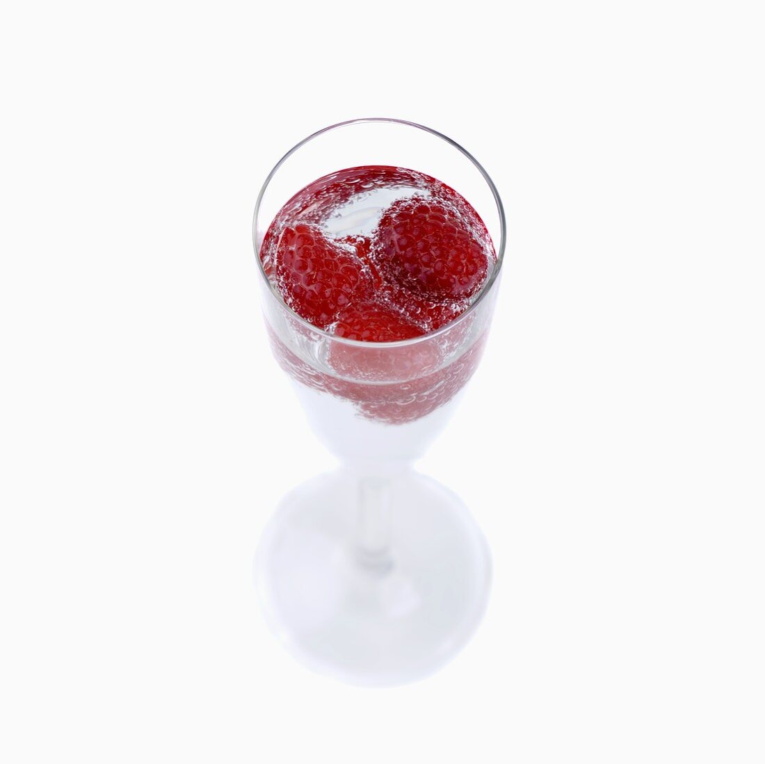 Mineralwasser mit Himbeeren im Stielglas