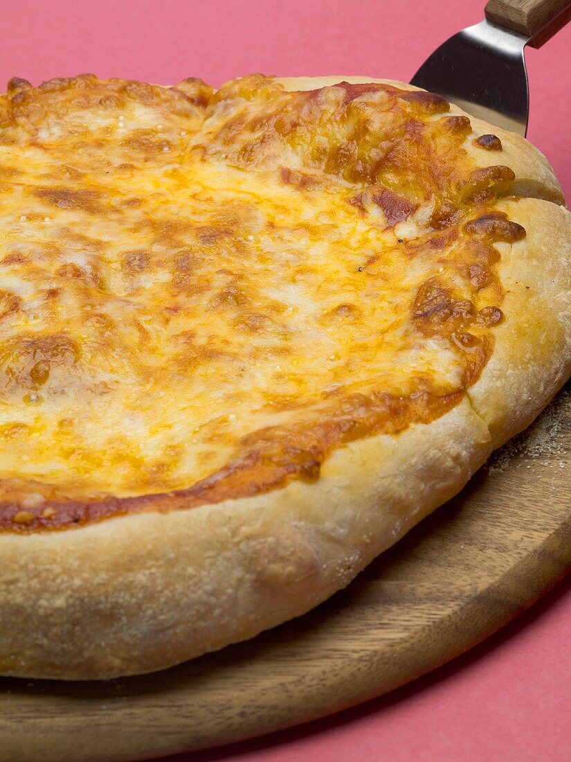Pizza Margherita (Tomaten-Käse-Pizza) auf Holzteller