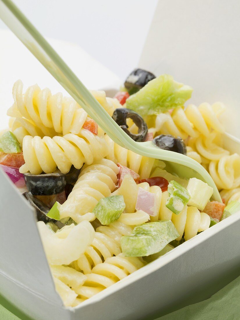 Fusilli with vegetables in take-away container (close-up)