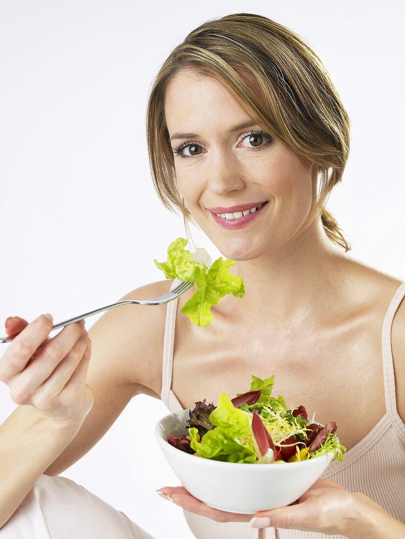 Frau isst gemischten Blattsalat