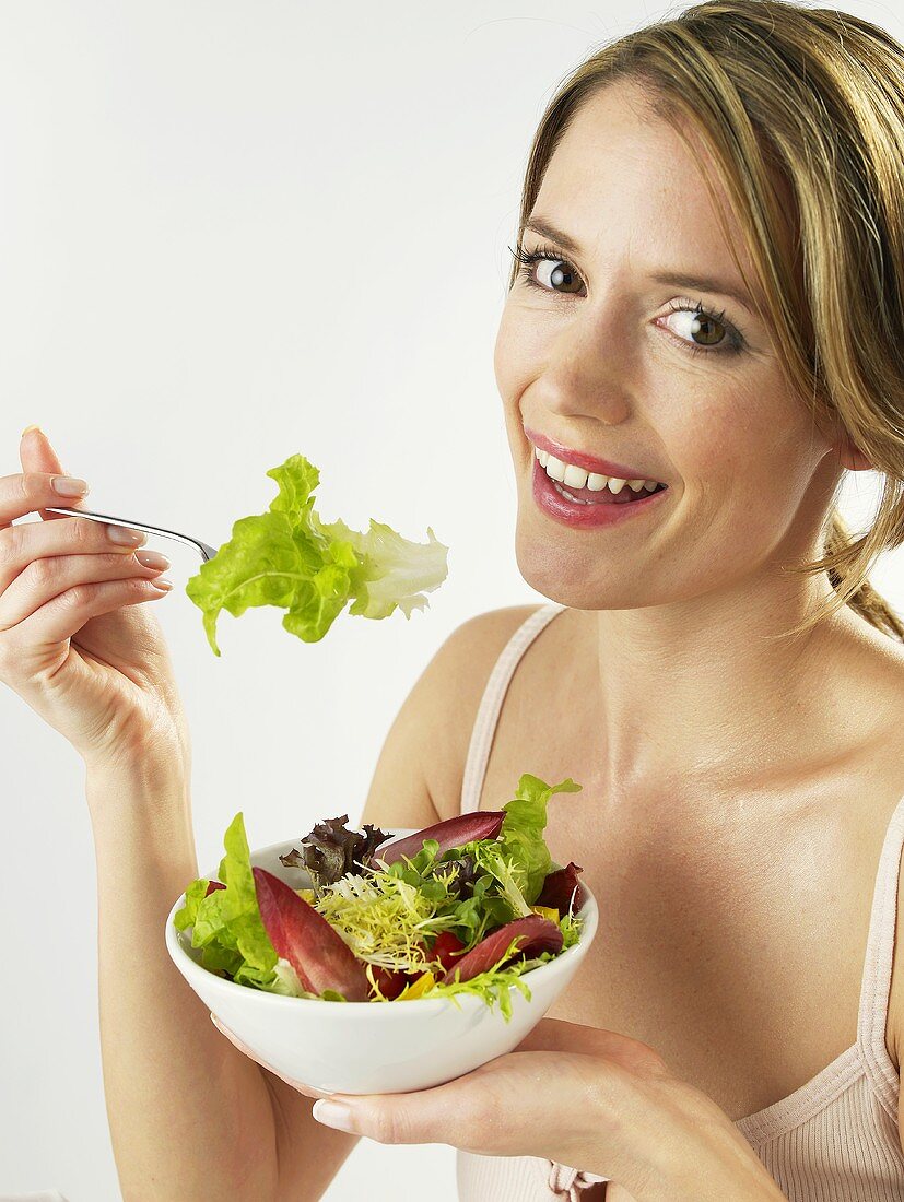 Woman eating mixed salad leaves