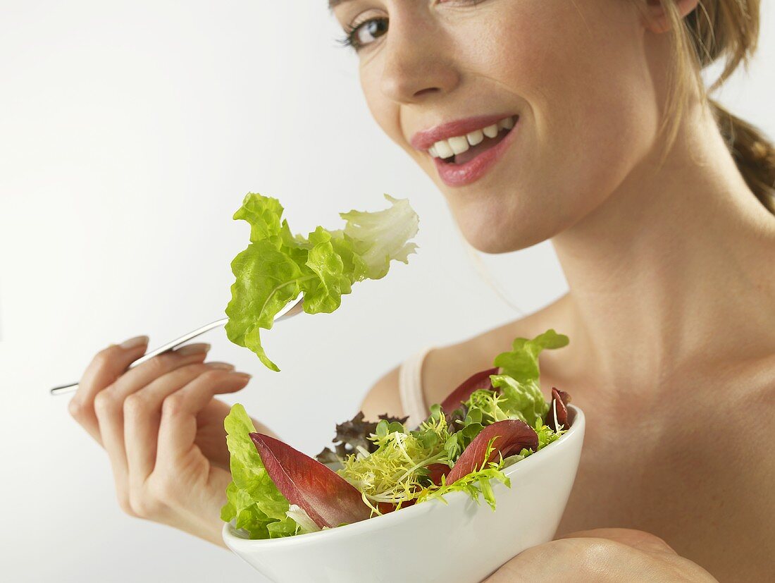Frau isst gemischten Blattsalat