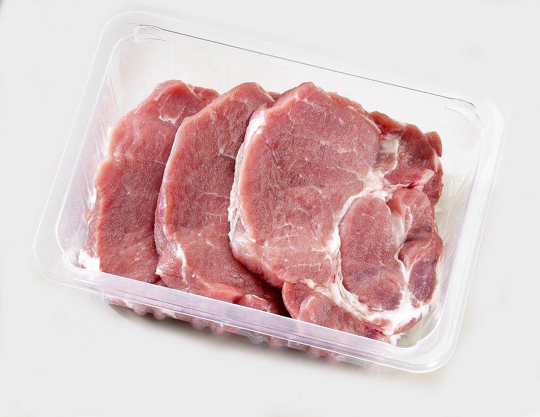 Pork neck steaks in plastic container