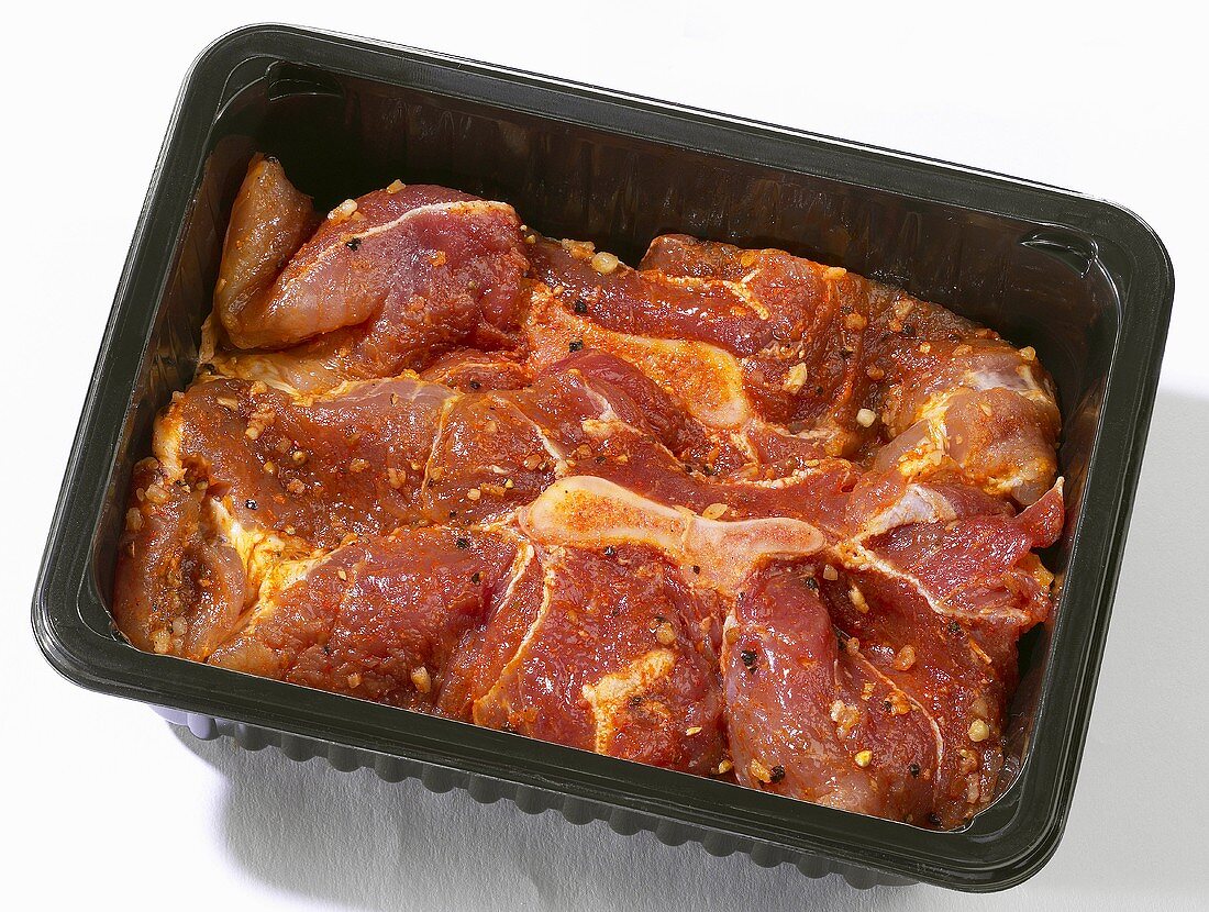 Marinated meat (for barbecuing) in plastic container