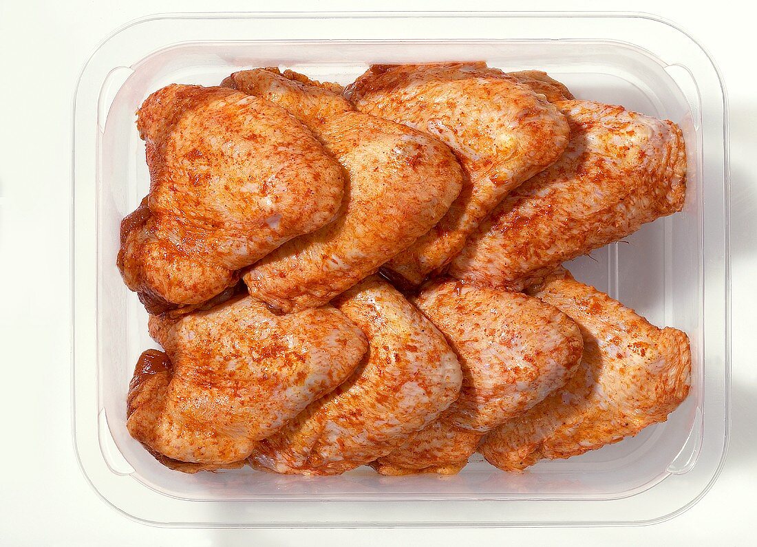 Spicy chicken wings in plastic container