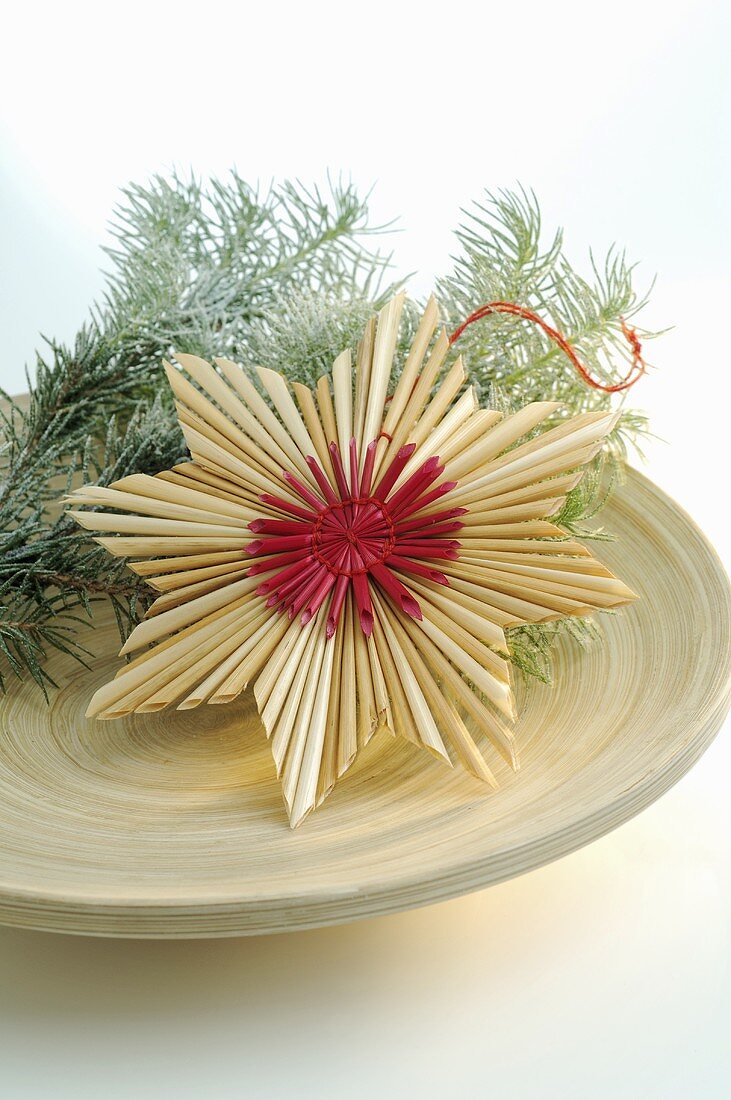 Straw star and fir sprigs on plate