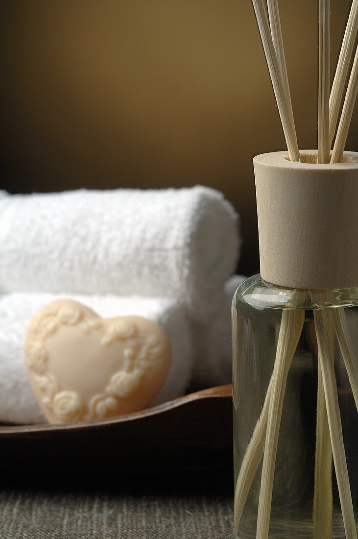 Scented oil, rolled white towels and soap