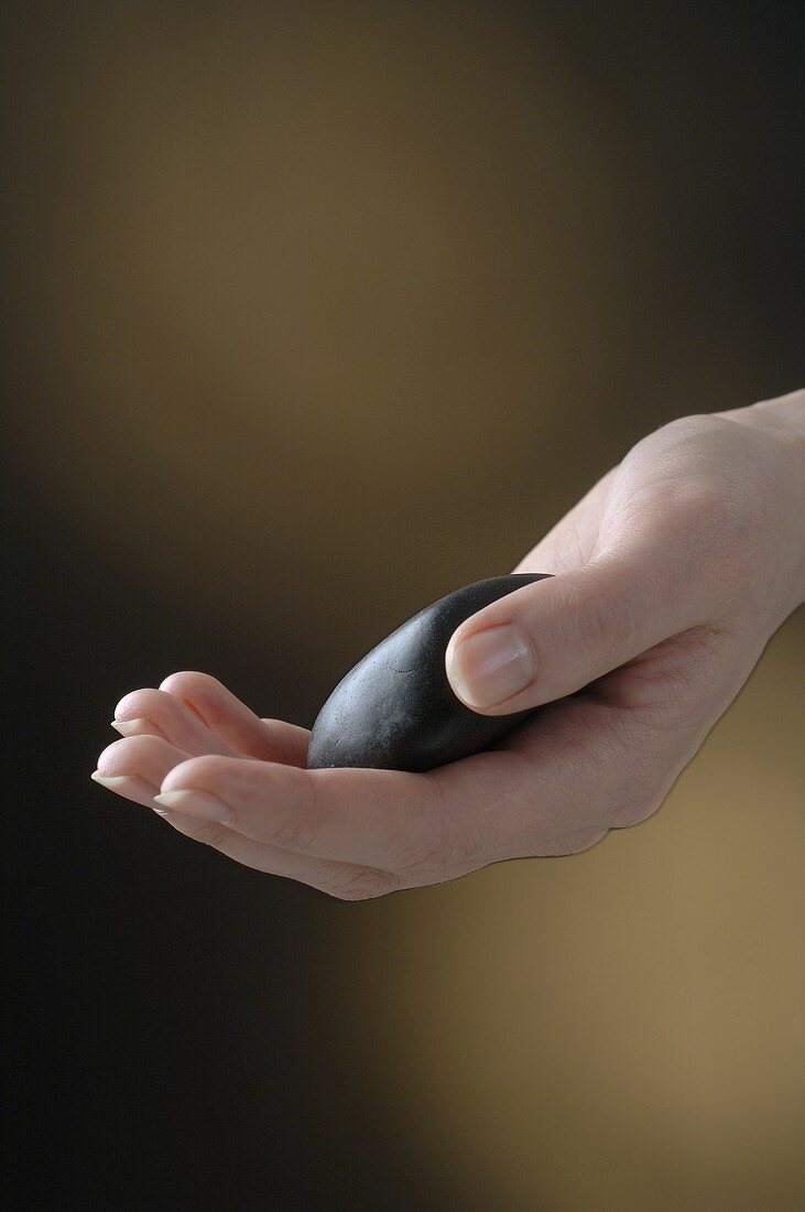 Hand holding a hot stone