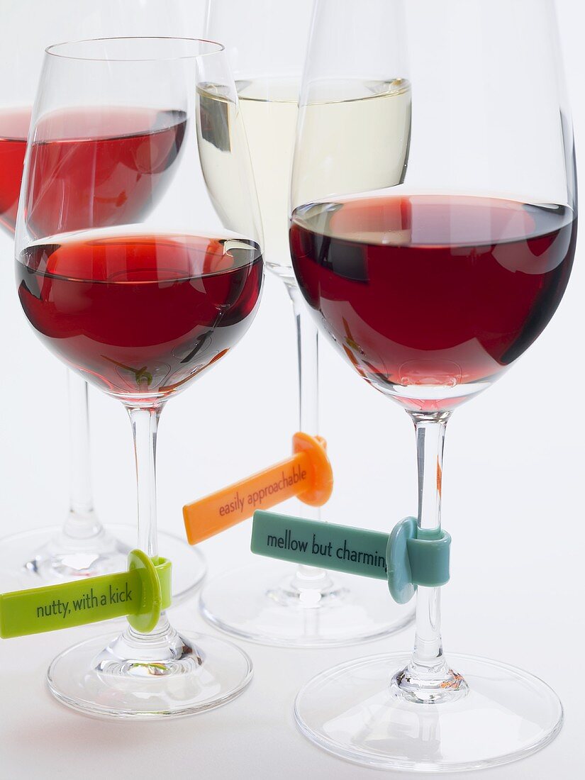Glasses of wine with plastic labels describing the wine