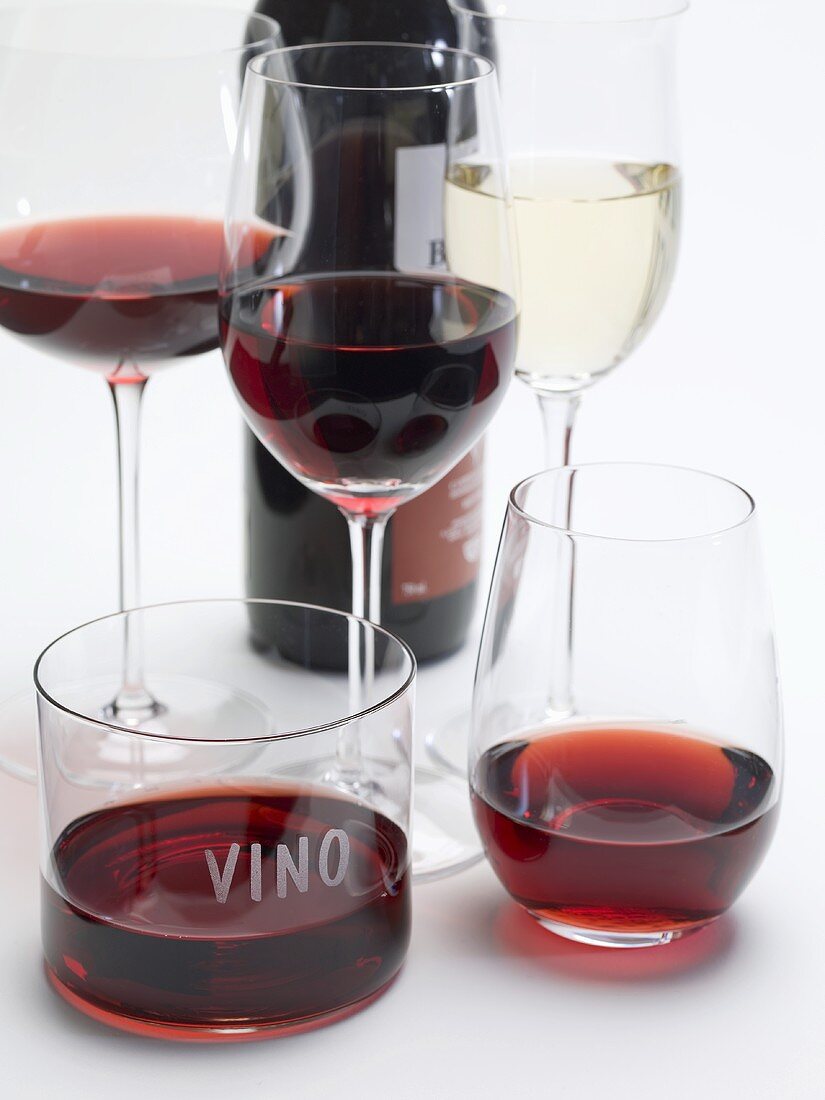 Red wine in different glasses, glass of white wine, red wine bottle