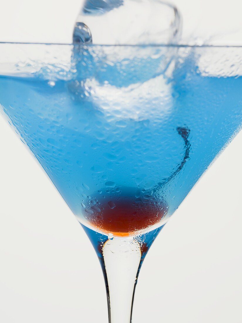 Cocktail mit Blue Curacao, Cocktailkirsche und Eiswürfel