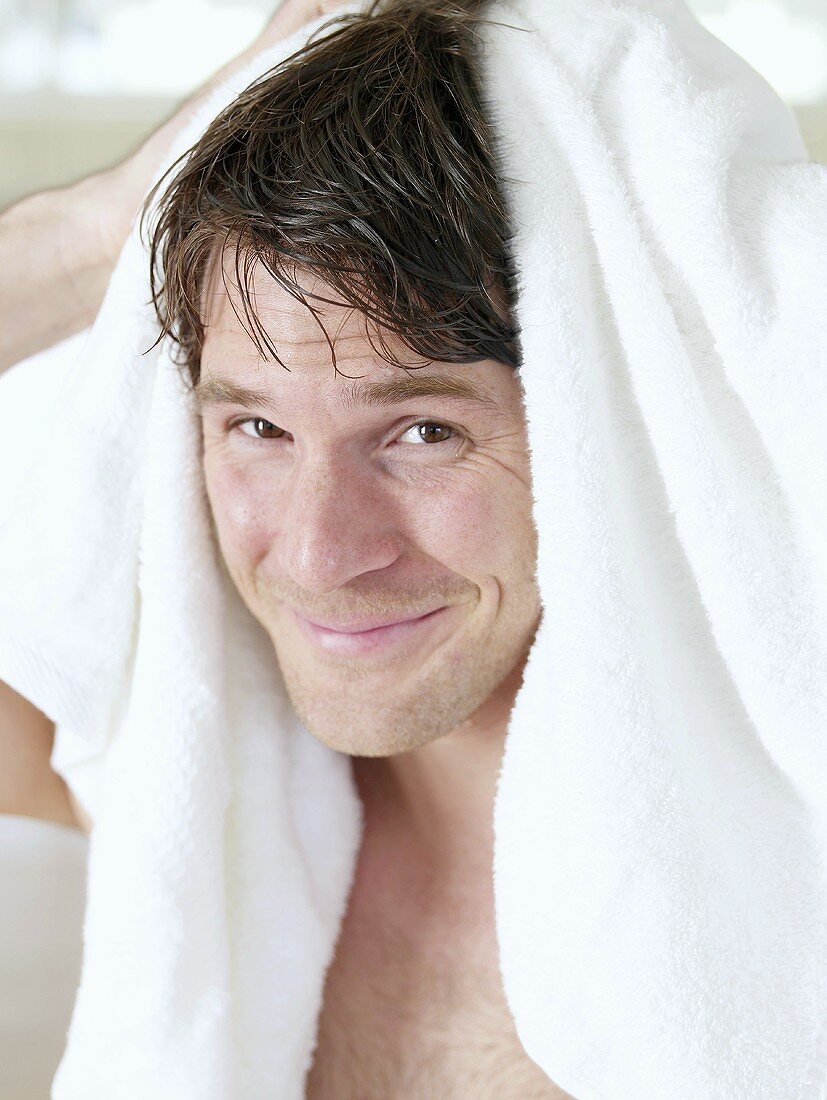 Man drying his hair with a towel