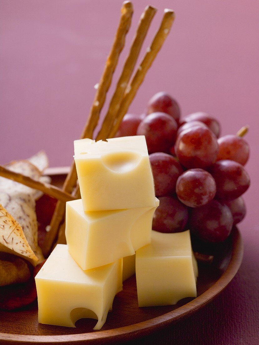 Cubes of cheese with grapes and salted sticks
