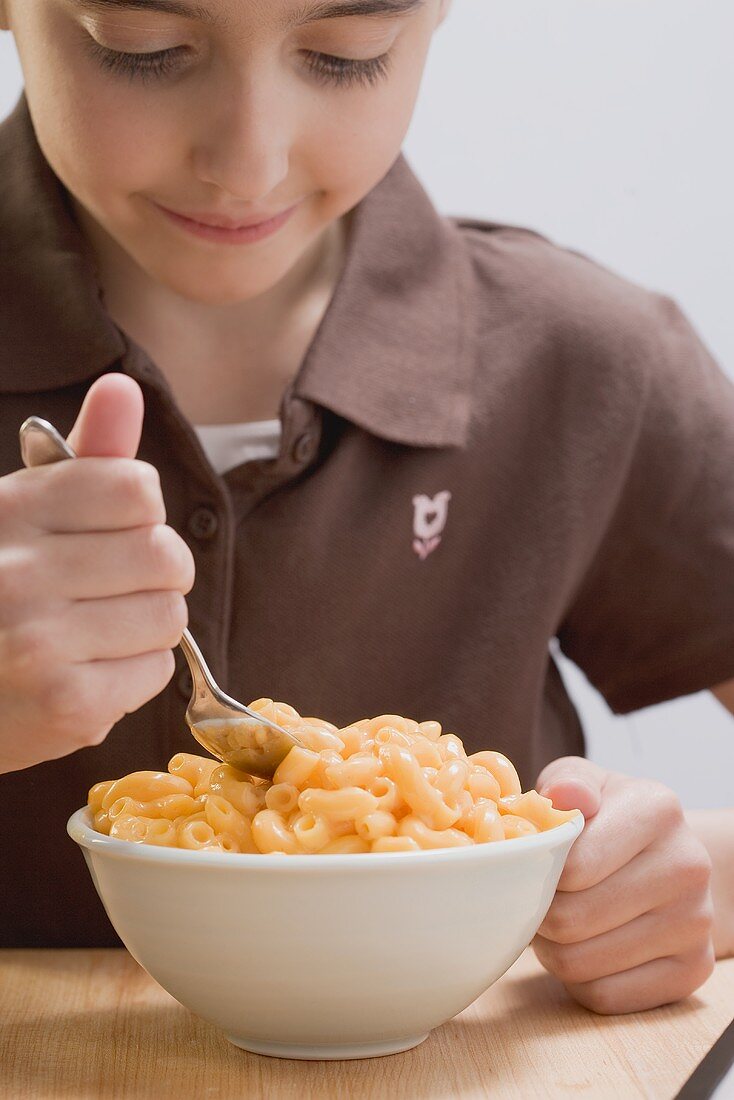 Little girl eating macaroni cheese