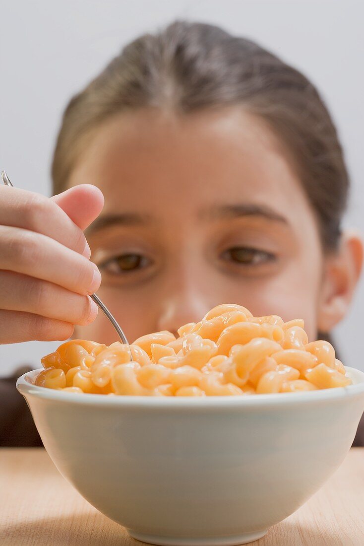 Kleines Mädchen isst Macaroni and Cheese