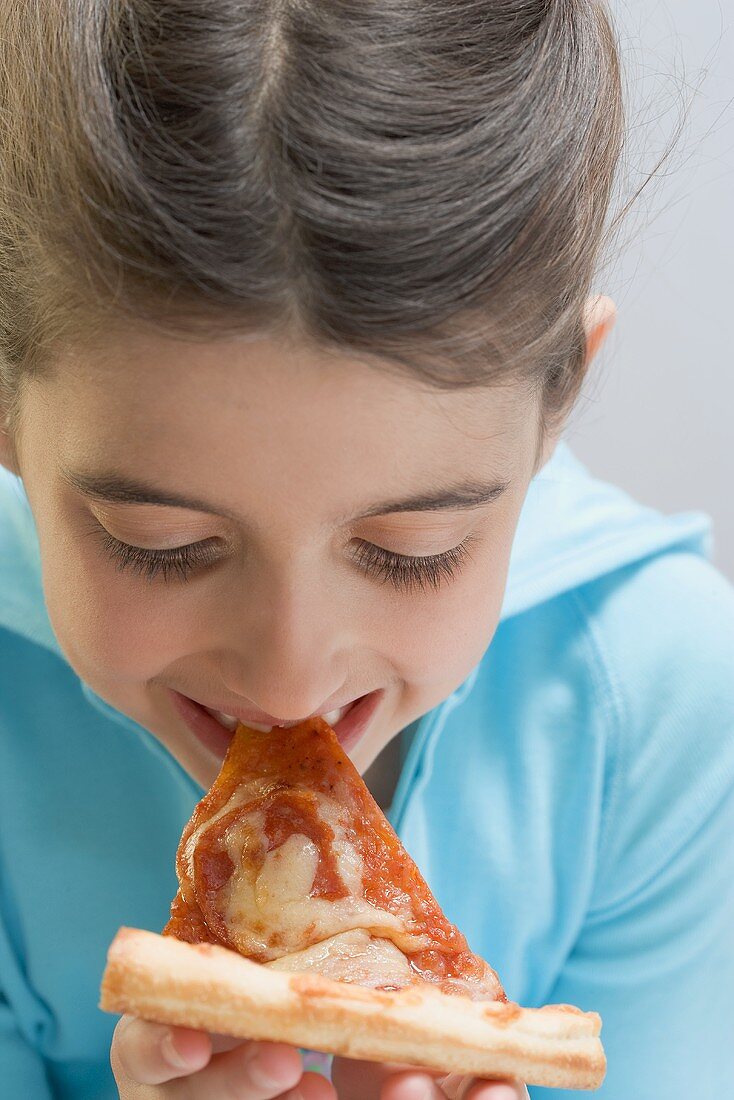 Kleines Mädchen isst Stück Pizza