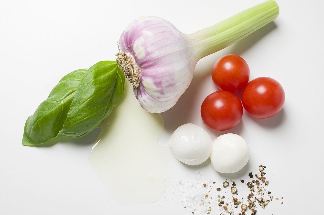 Knoblauch, Tomaten, Mozzarella, Gewürze, Öl und Basilikum