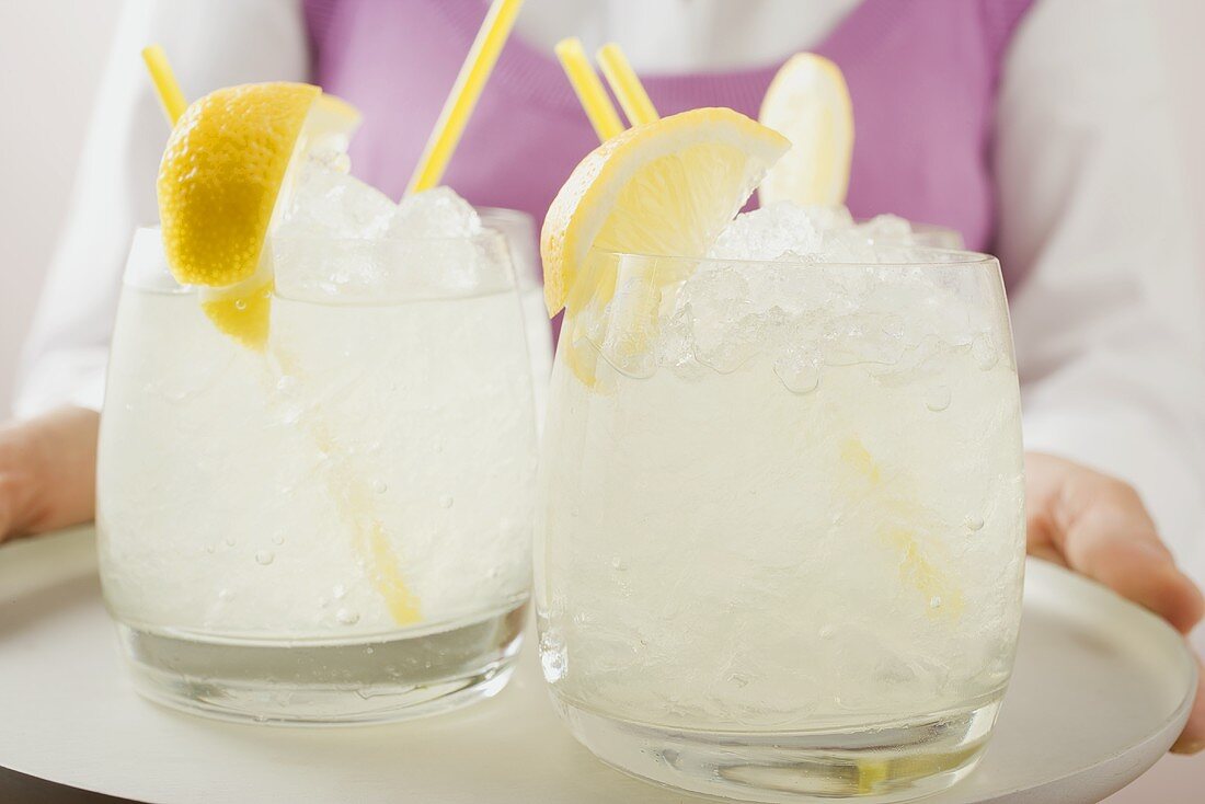 Woman holding a tray of glasses filled with lemonade