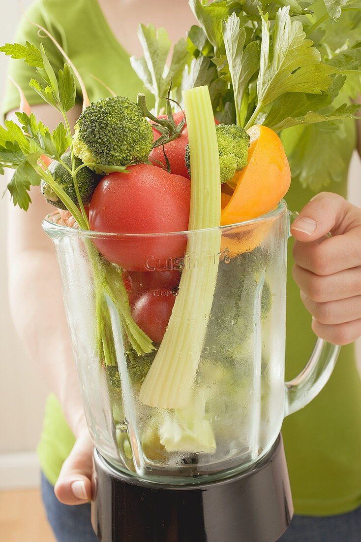 Woman holding fresh vegetables in liquidiser