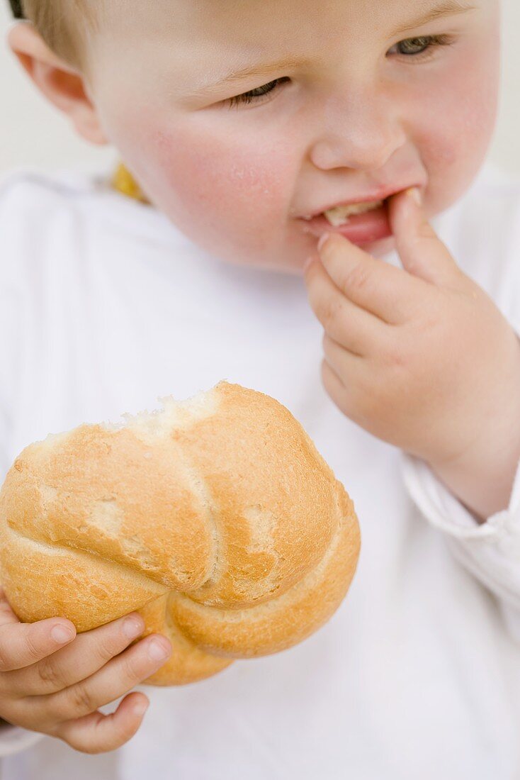 Baby eating a bread roll