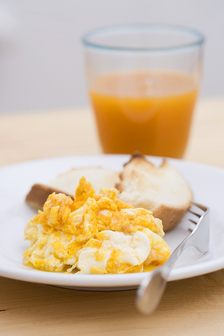 Scrambled egg, toast and glass of fruit juice