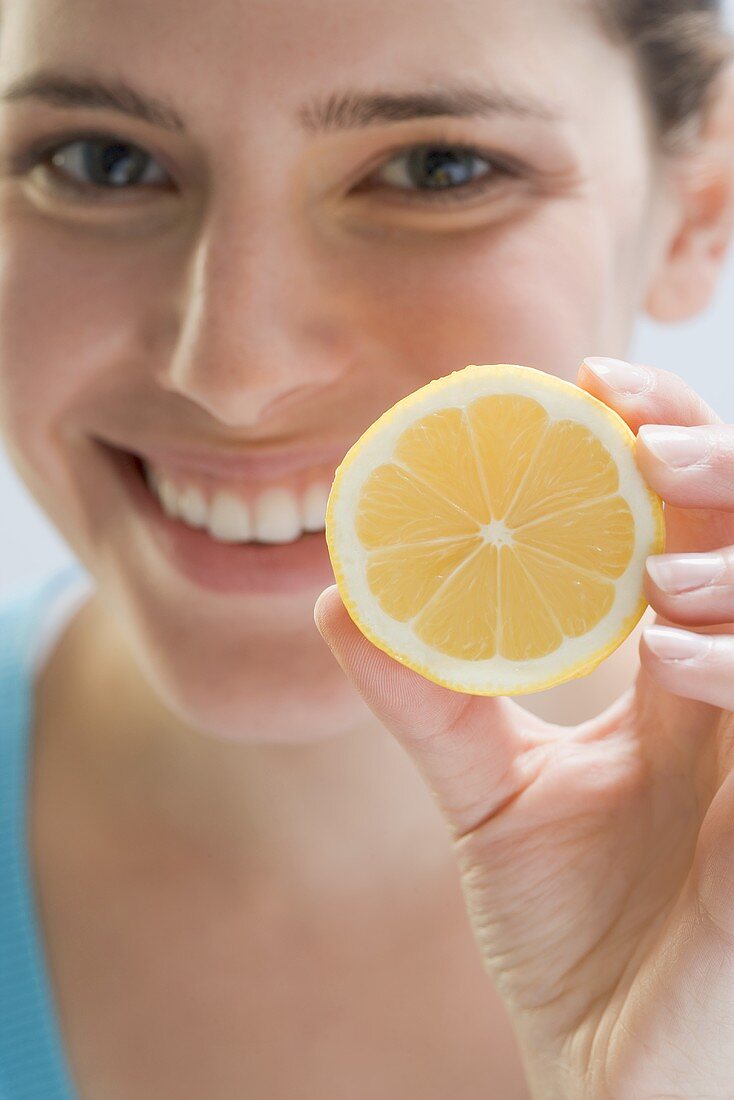Junge Frau hält Zitrone