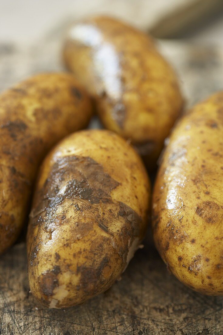 Freshly washed potatoes on old chopping board