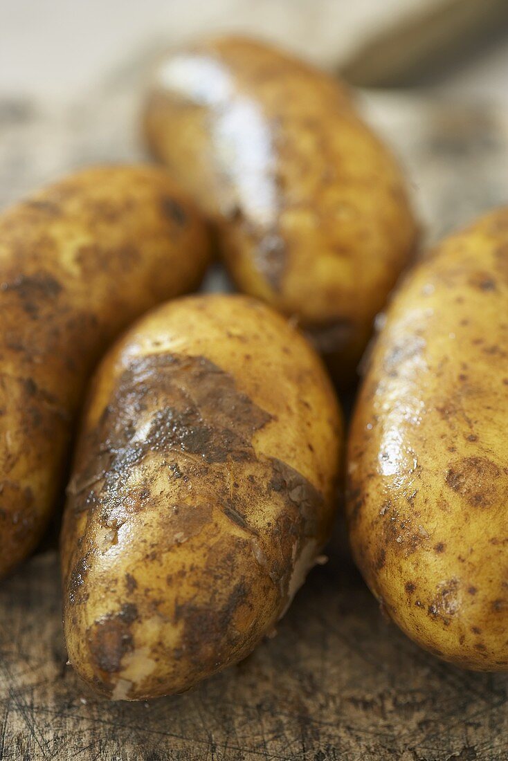 Frisch gewaschene Kartoffeln auf altem Schneidebrett