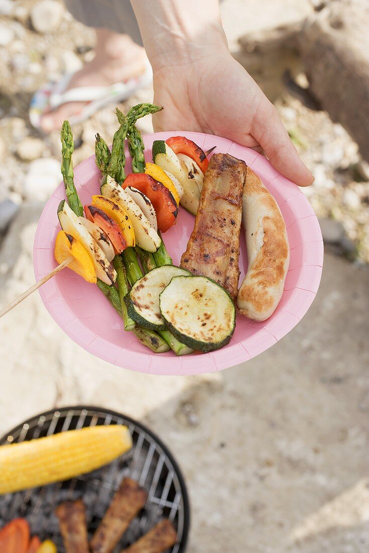 Hand hält Grillteller