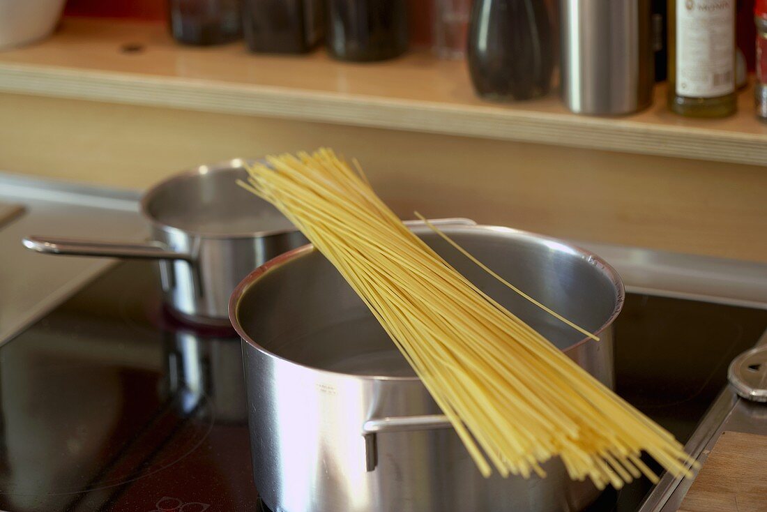 Spaghetti auf Kochtopf am Herd