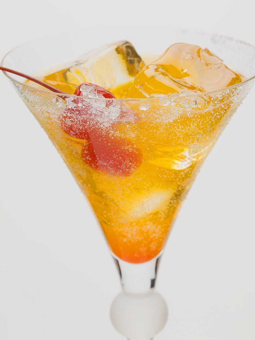Tequila Sunrise mit Eiswürfeln und Cocktailkirschen
