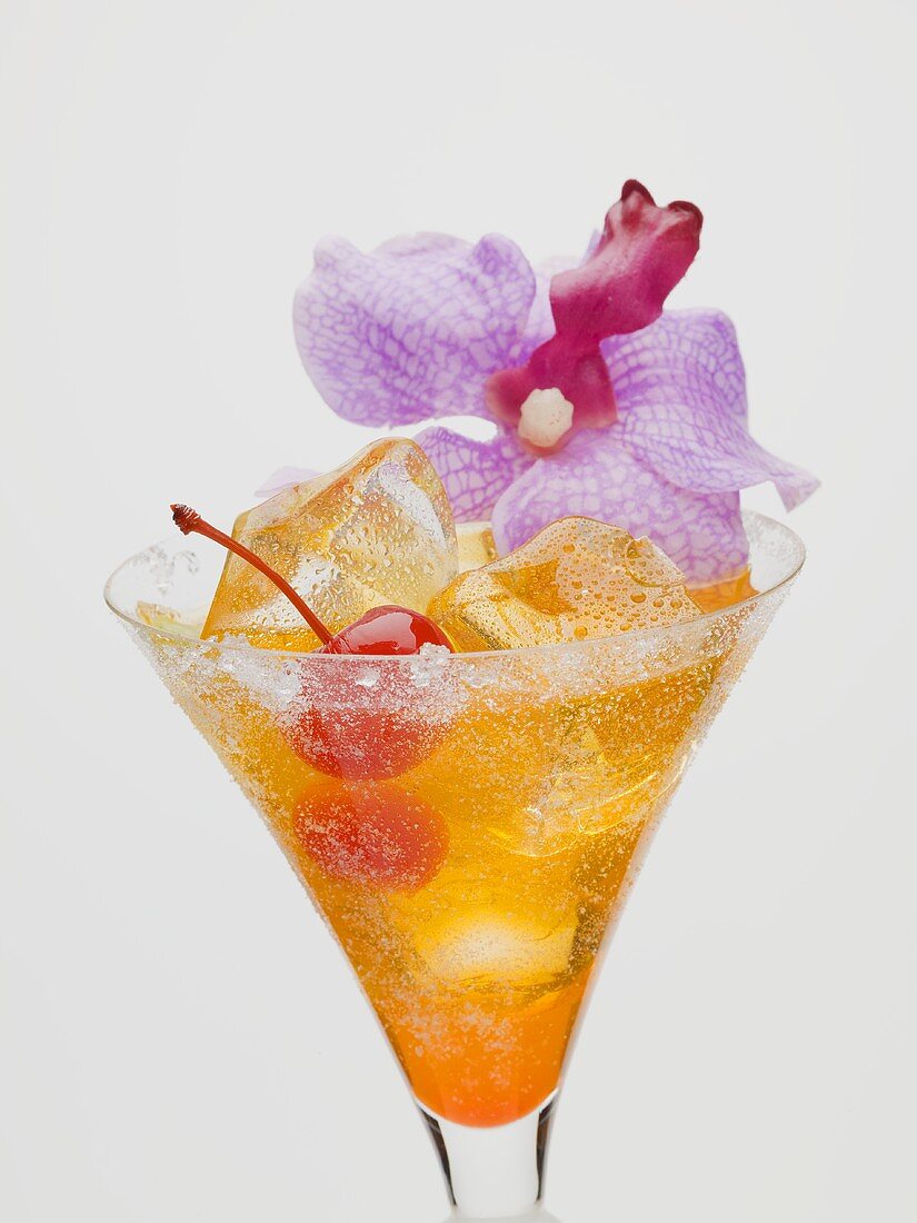 Tequila Sunrise mit Cocktailkirsche und Orchidee