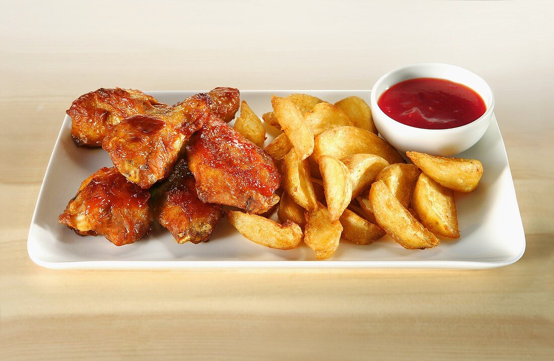 Chicken wings with potato wedges and ketchup