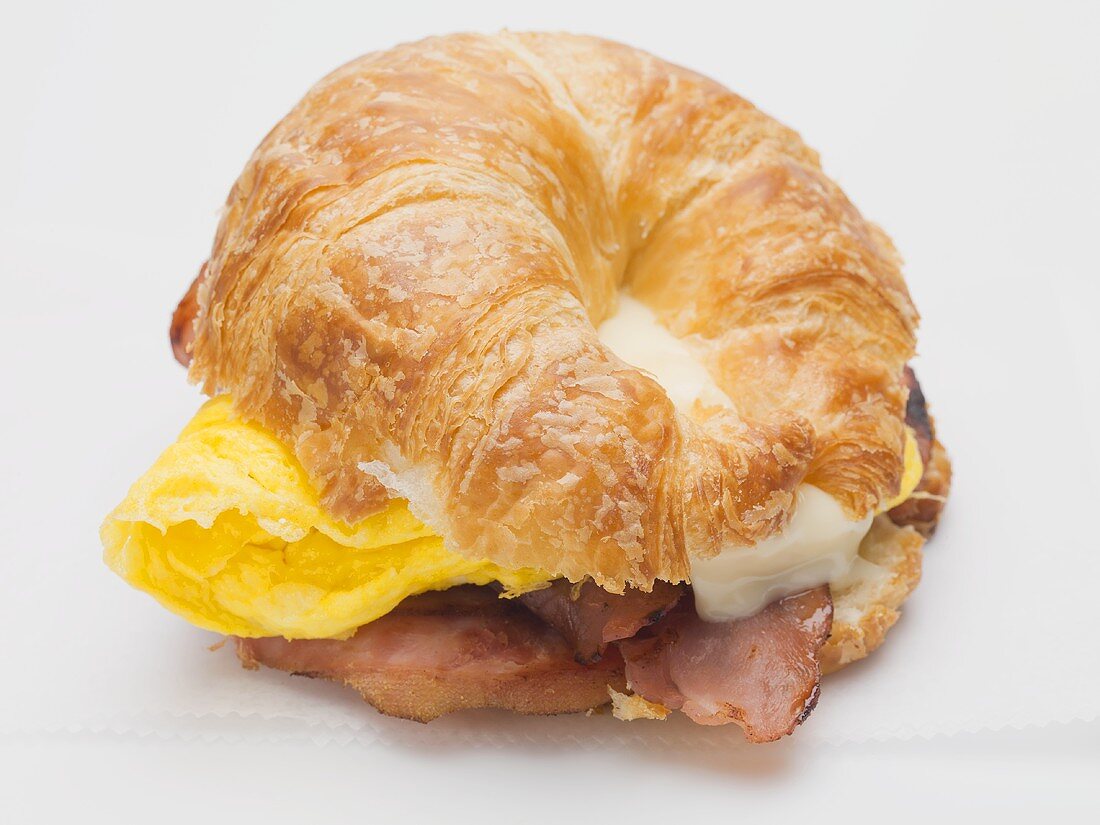 Croissant mit Bacon, Rührei und Käse