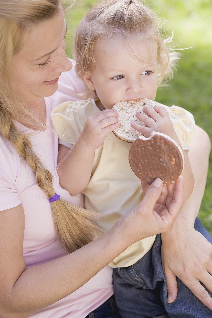 Mother and young daugher eating rice cakes