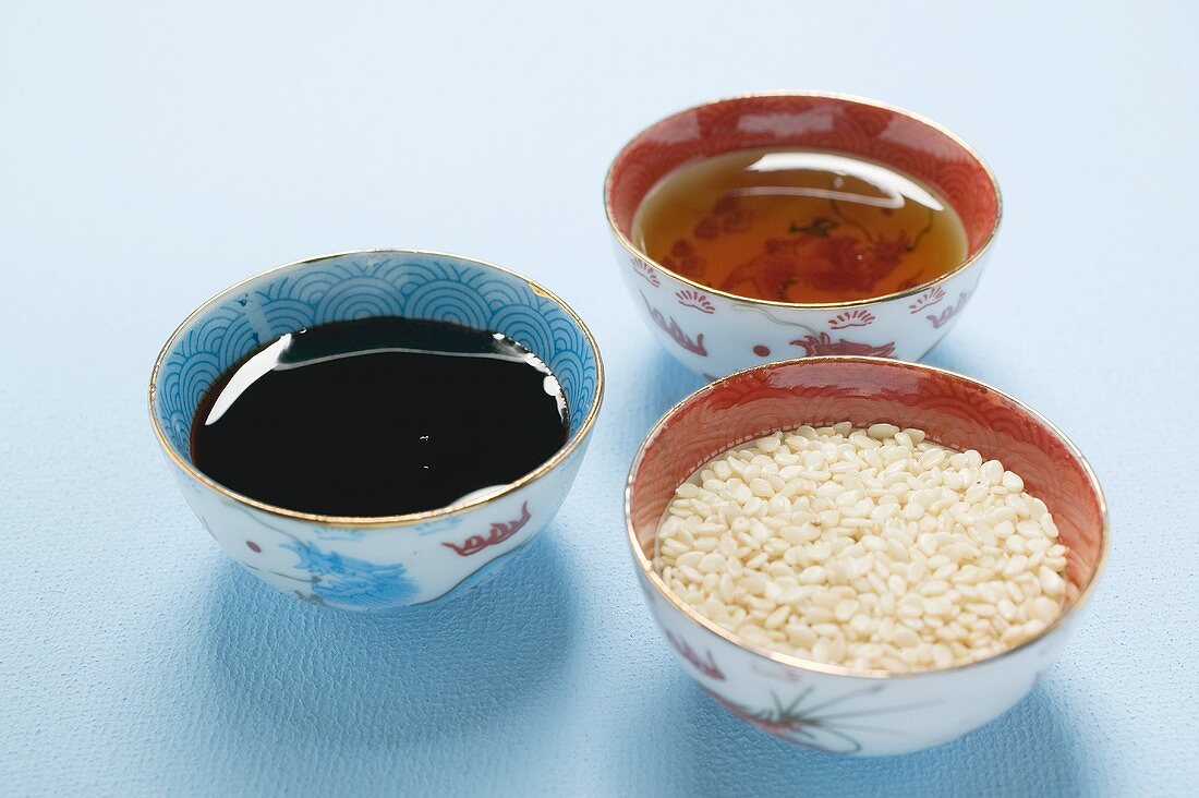 Asian sauces and sesame seeds in small bowls
