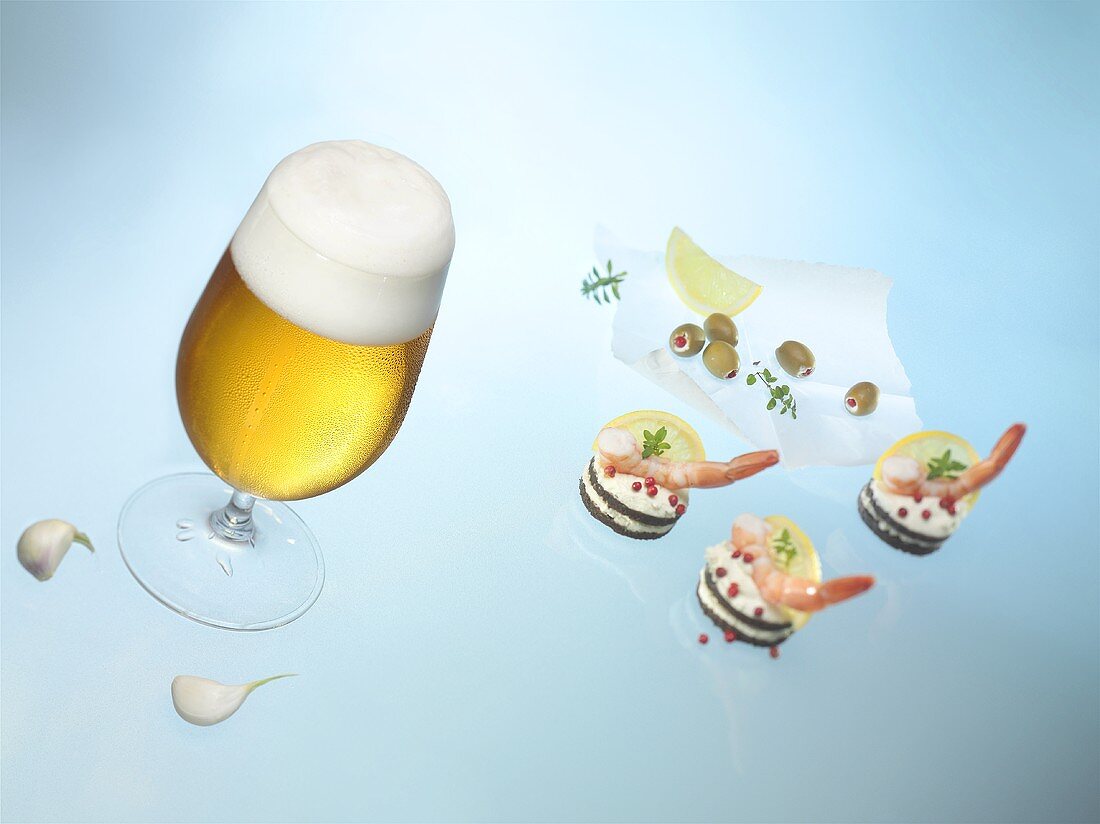 Glas Bier und Pumpernickeltaler mit Garnelen
