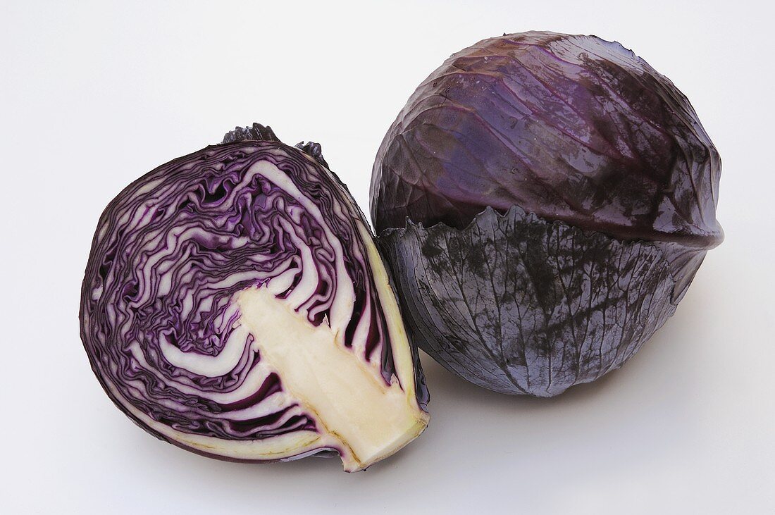 Whole red cabbage and half of a red cabbage
