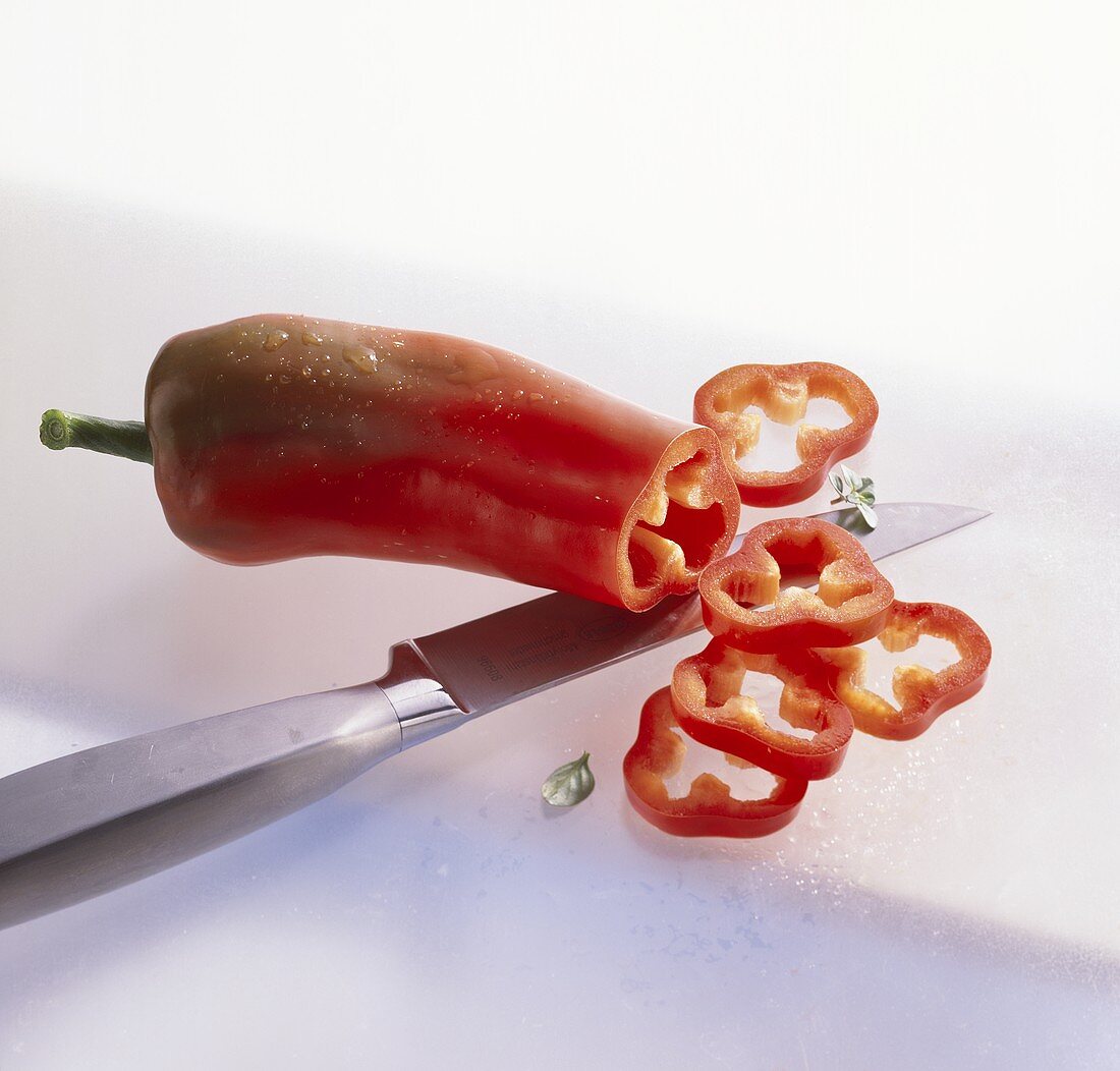 Pointed red pepper, partly sliced with kitchen knife
