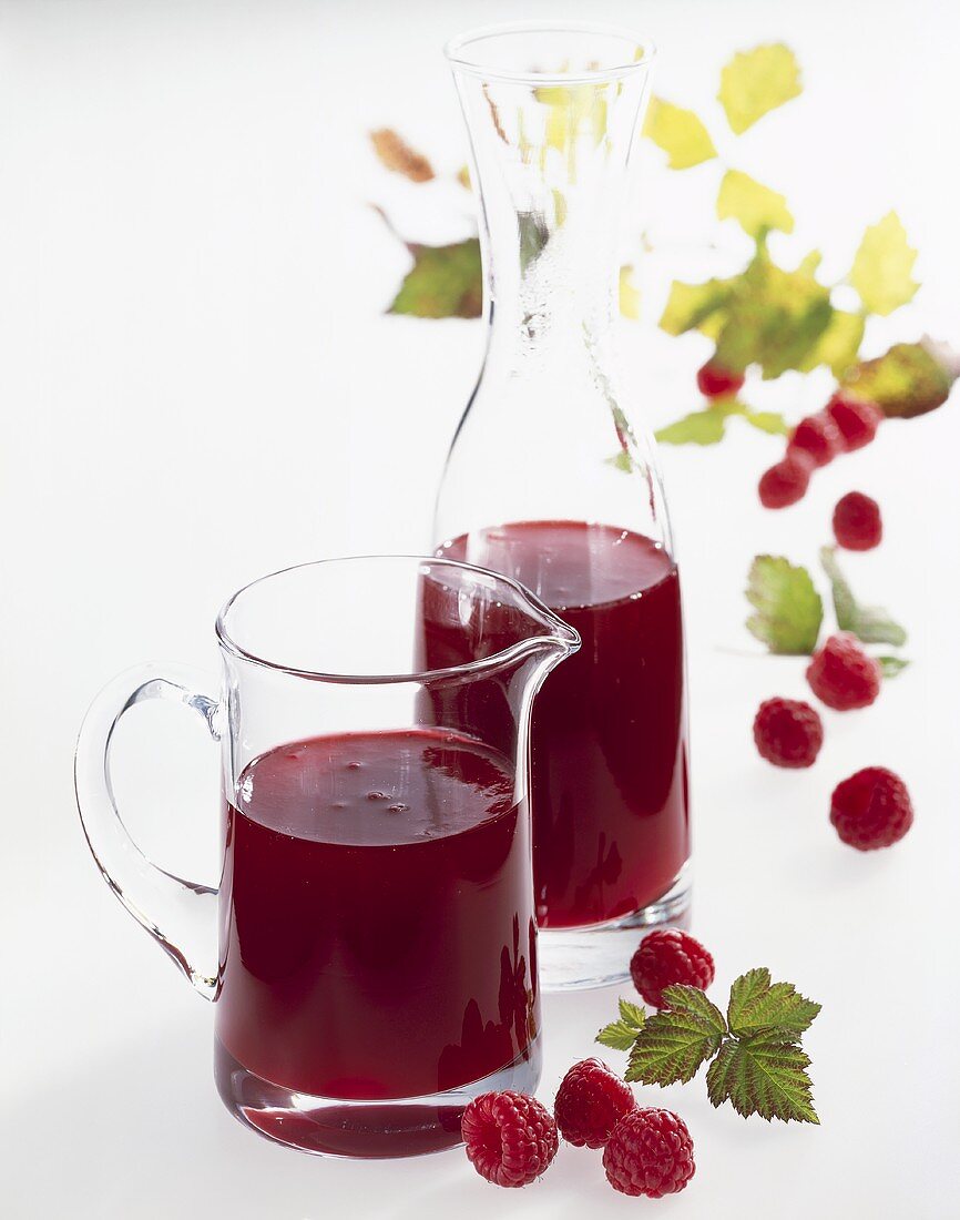 Raspberry syrup in a carafe and a jug