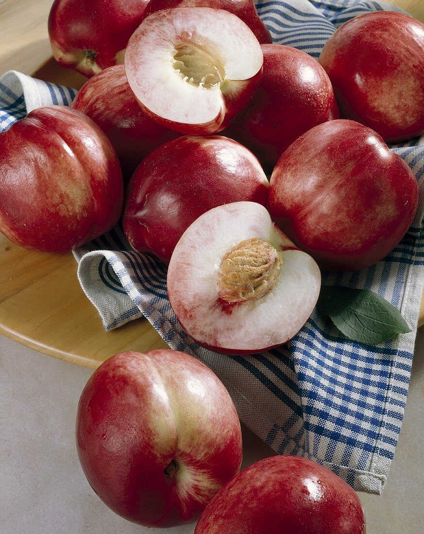 Whole and halved nectarines with a tea towel