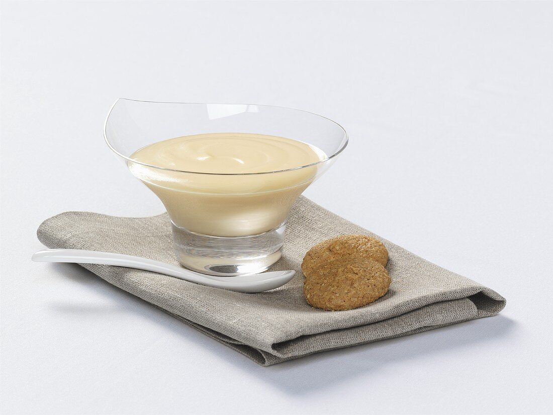 Vanilla cream in glass bowl and two cookies