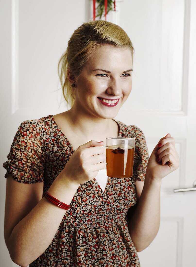 Junge Frau mit einem Glas Punsch