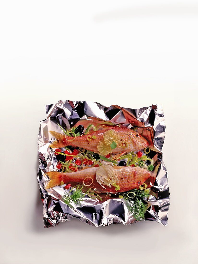 Red mullet with vegetables and herbs on aluminium foil