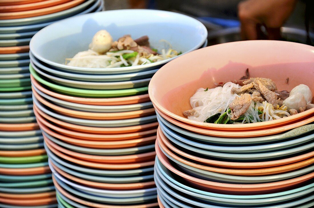 Noodle soup with meat prepared in plastic bowls (Thailand)