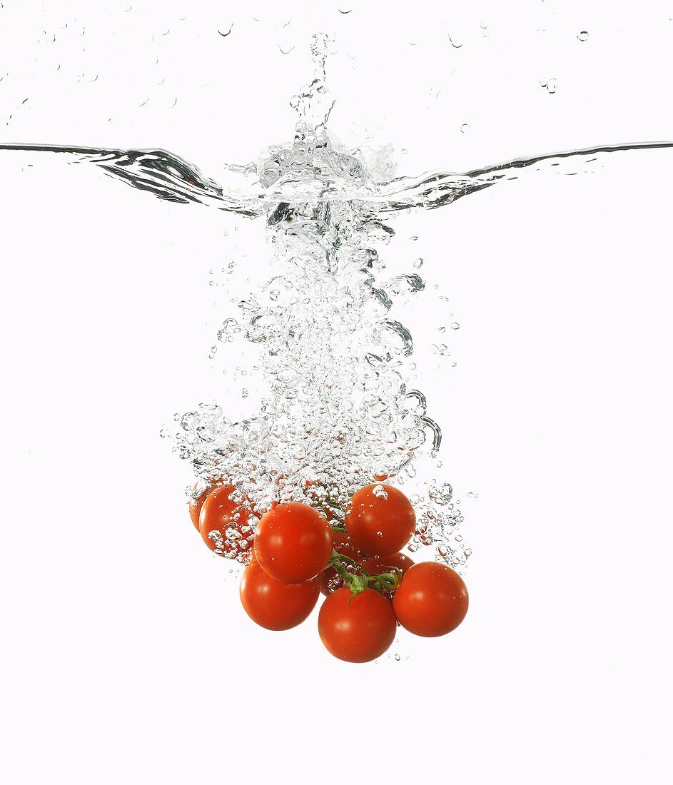 Cherry tomatoes falling into water